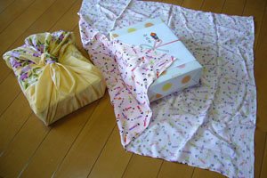 2 Furoshiki die benutzt werden um eine Box zu verpacken.