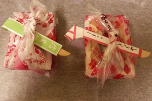 2 Furoshiki in Weiß mit roten Motiven.