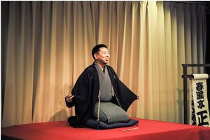 Mann mit Kimono und Haori auf einer Bühne. 