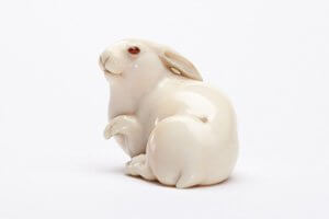 Netsukes aus Elfenbein. Ein Hase mit roten Augen.